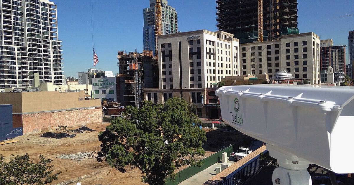 large side view of construction camera with construction site in the distance