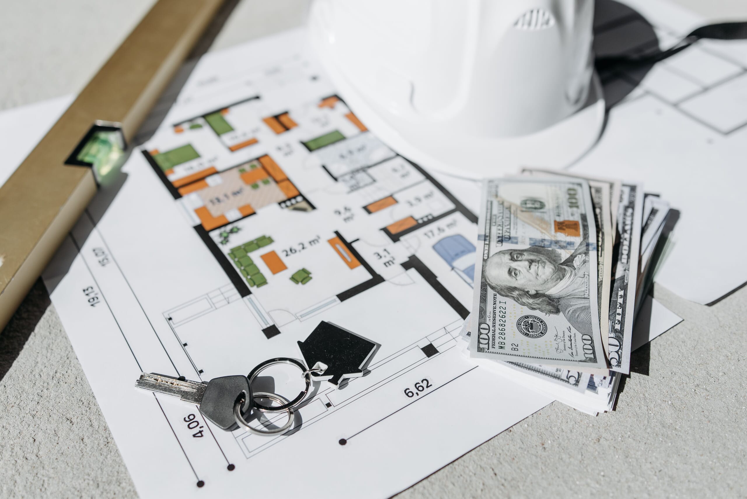 money on top of construction site map and keys