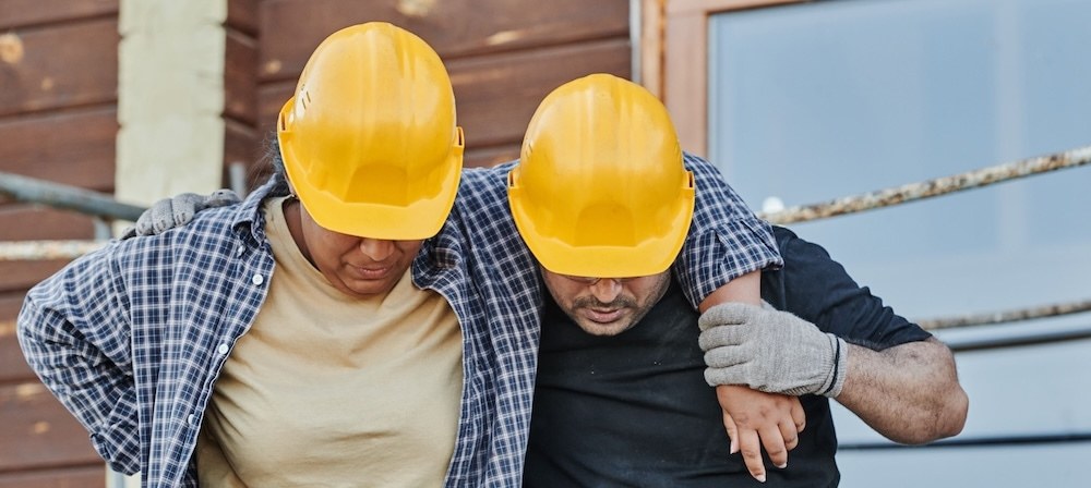 Construction worker helping an injured coworker