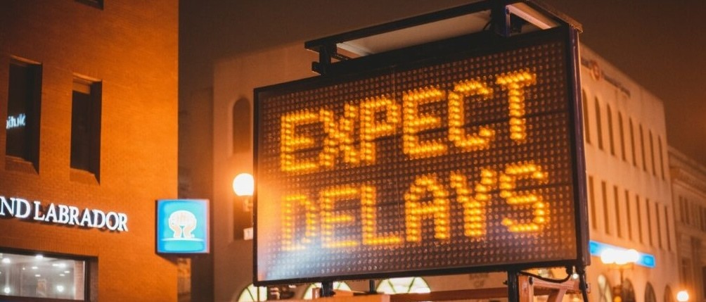 Expect Delays sign on a city street at night