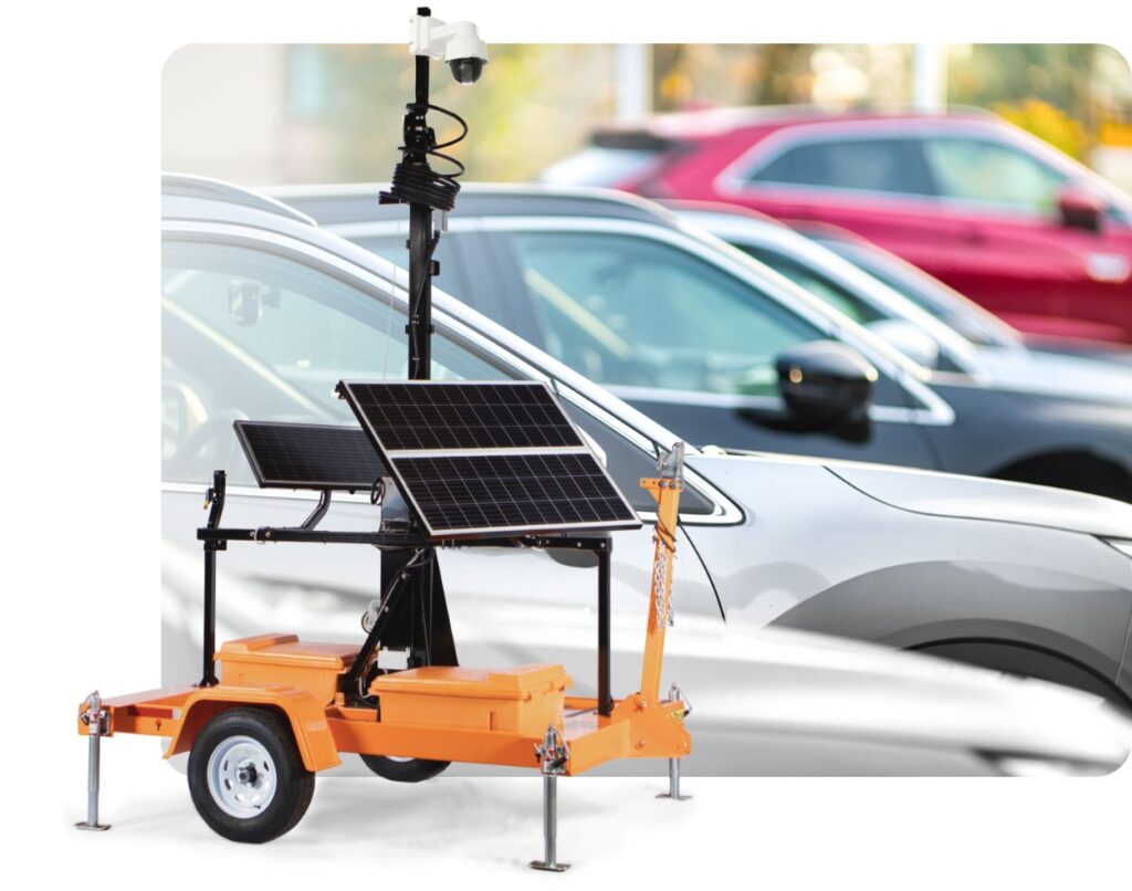 A mobile surveillance trailer in front of a car dealership