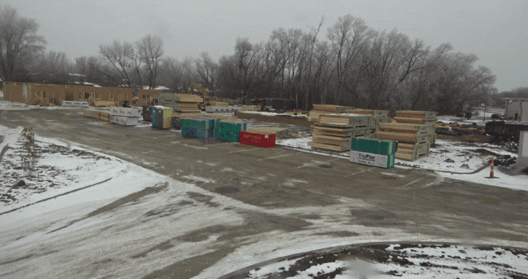 An image of a bunch of building materials and lumber sitting on out on a jobsite