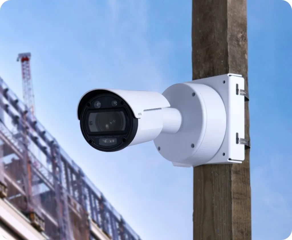 An 8K IR Fixed Construction Camera mounted on a wooden pole on a construction site