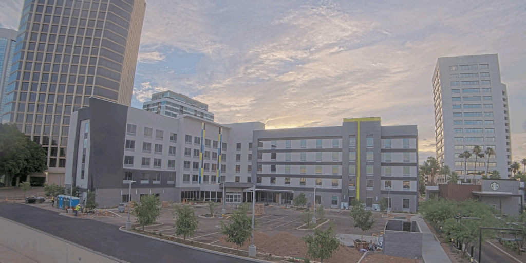 Hilton hotel with a sunset in the background and high-rises next to it captured by a construction camera