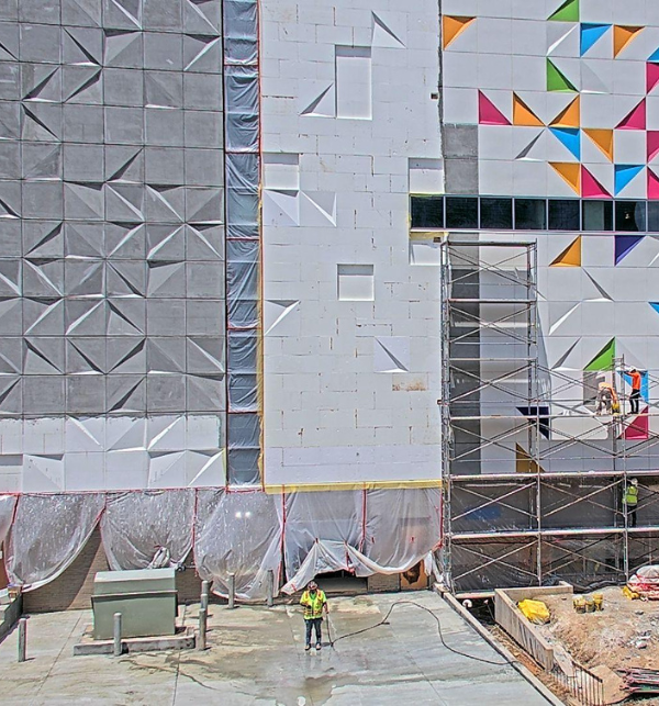 Kaleideum's geometric colorful wall being constructed by workers in PPE