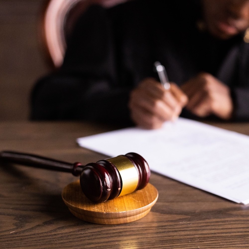 Gavel beside a person signing a document