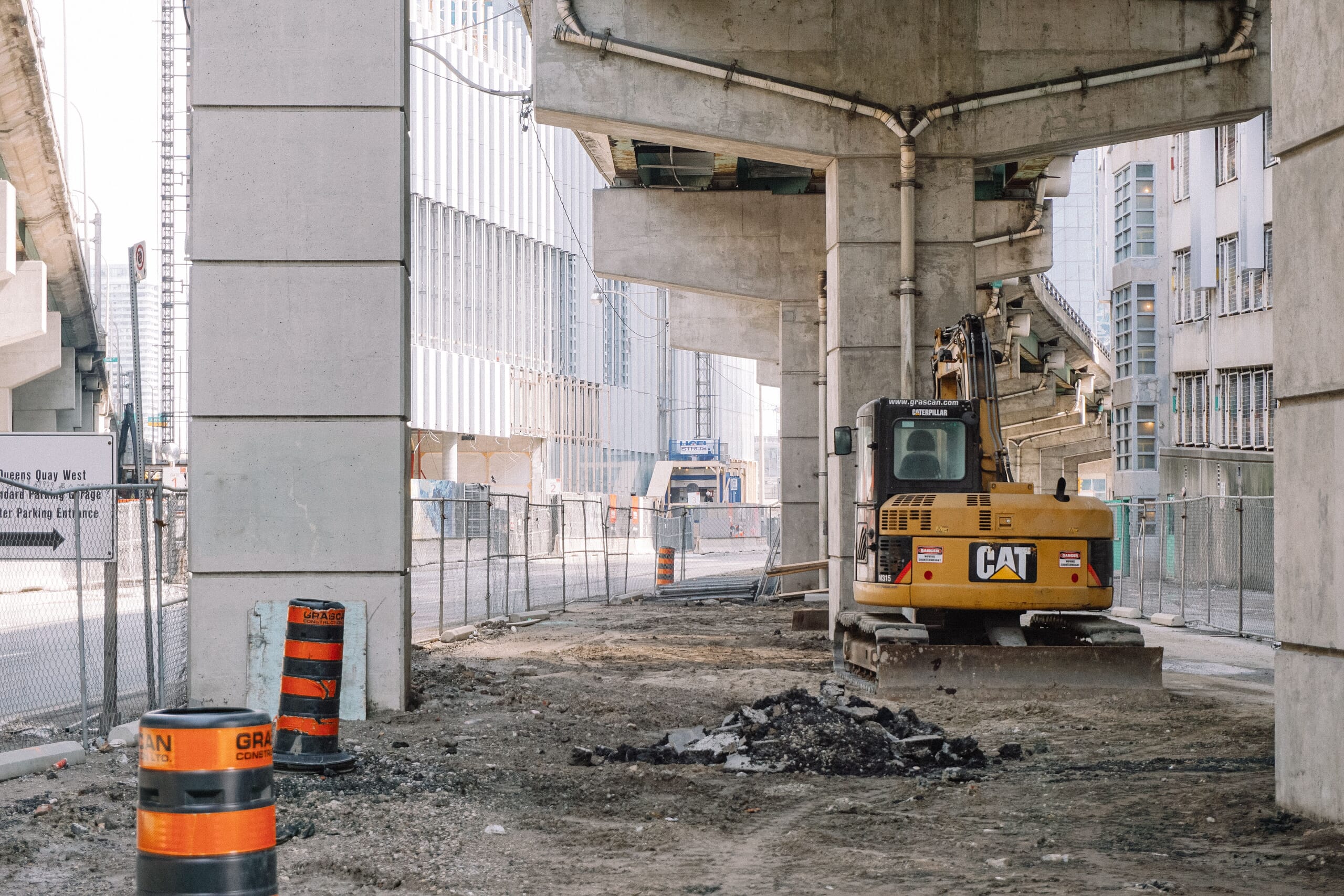 Excavator working under a highway overpass