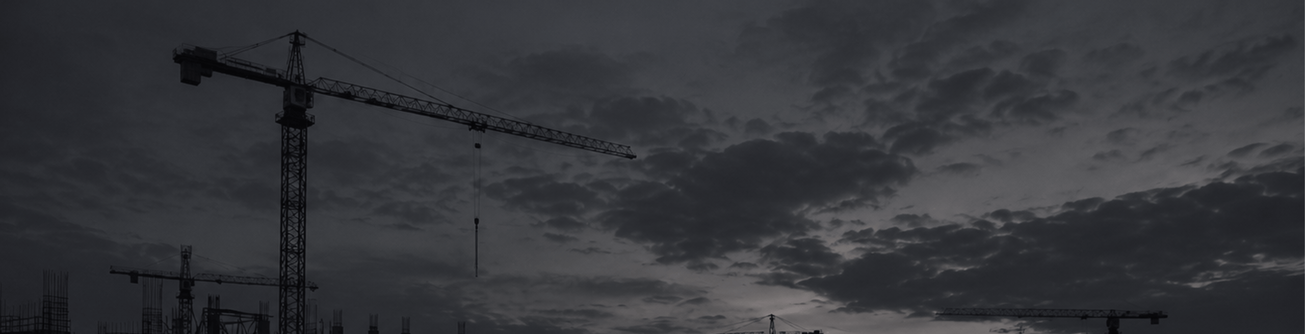 Tower crane against a dark cloudy sky
