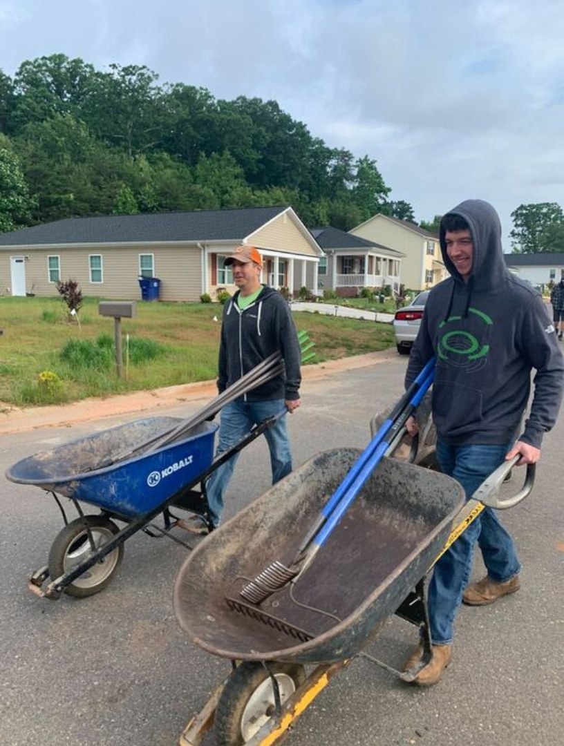 TrueLook volunteers pushing wheelbarrows at a Habitat for Humanity home build