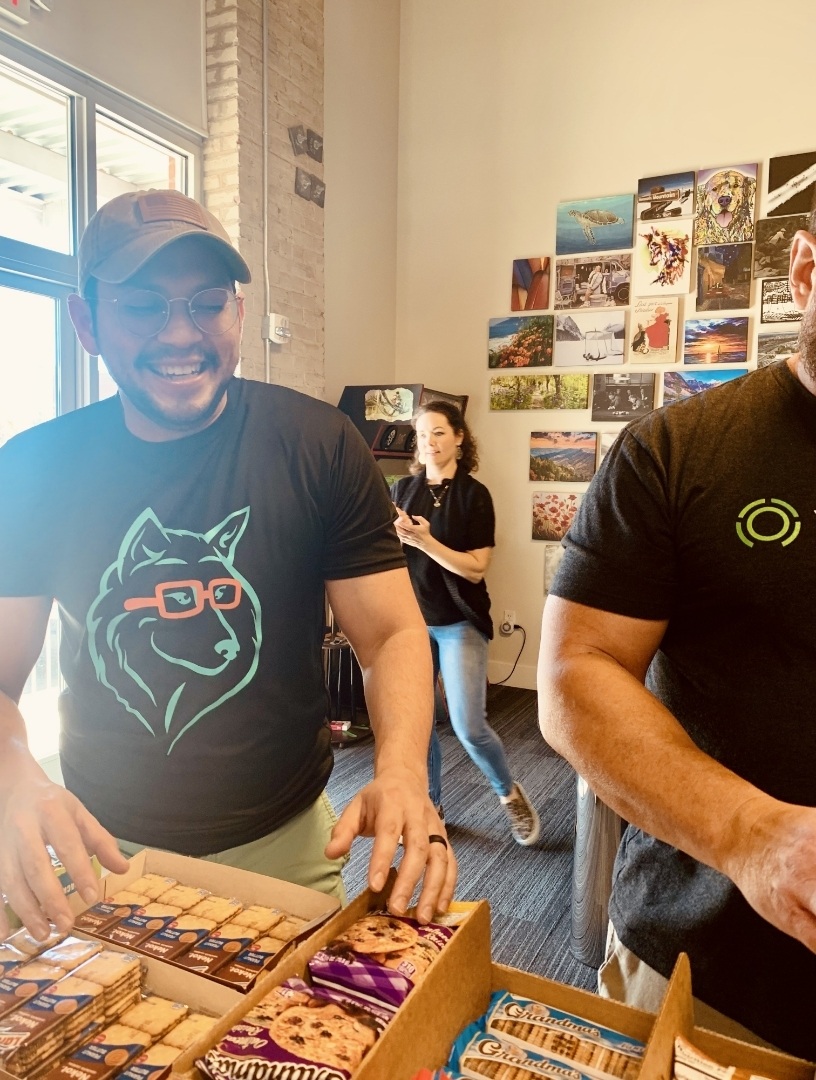 Smiling TrueLook team members assembling snack boxes during a volunteer event