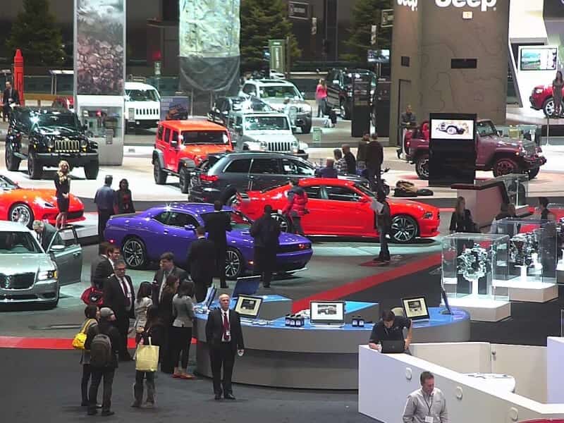 Crowded auto show floor with cars on display