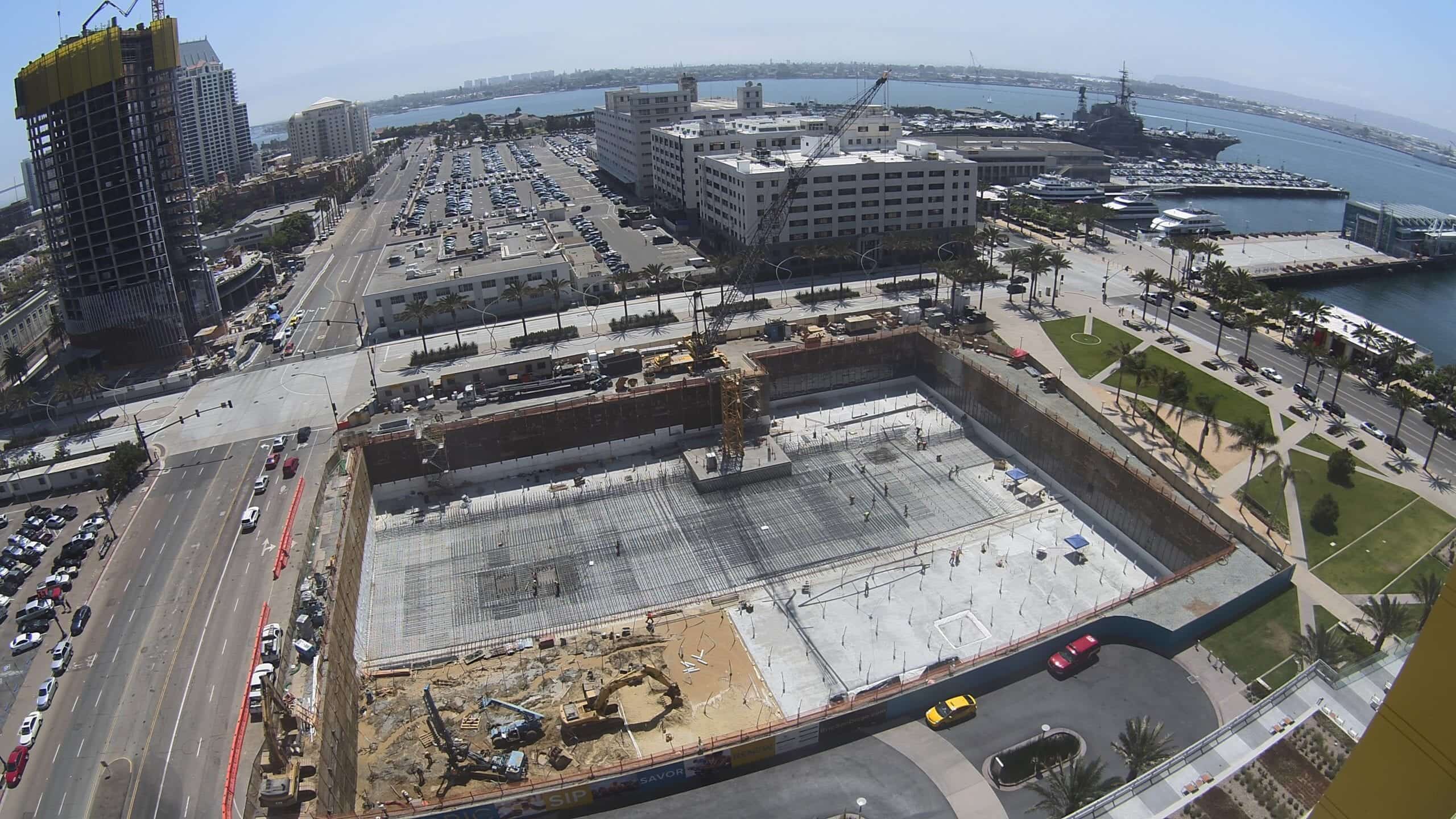 Aerial camera view of a large excavation site in a waterfront city