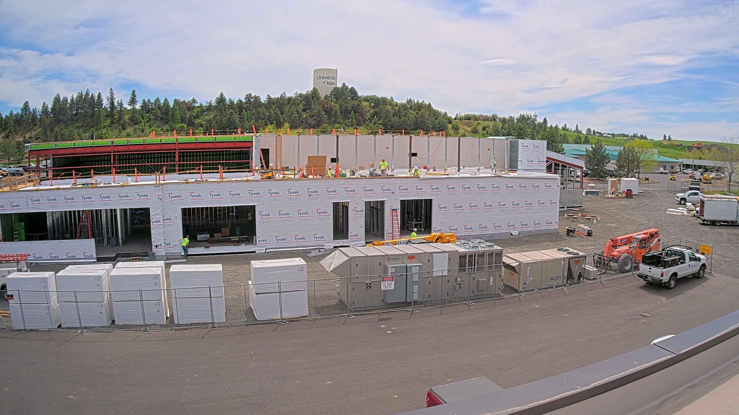 University of Idaho Meat Science and Innovation Center under construction covered in Tyvek Housewrap and materials and a job trailer sitting out captured by a construction camera