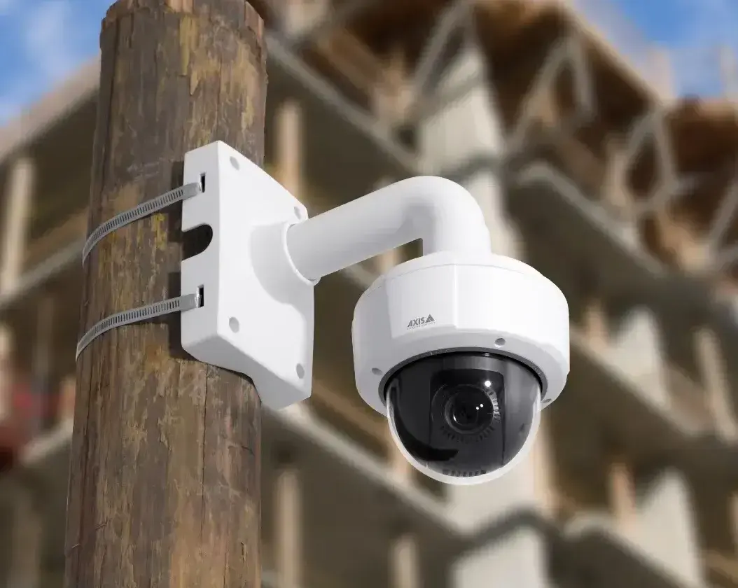 2K PTZ Construction site camera mounted to a wooden pole watching an active jobsite in the background