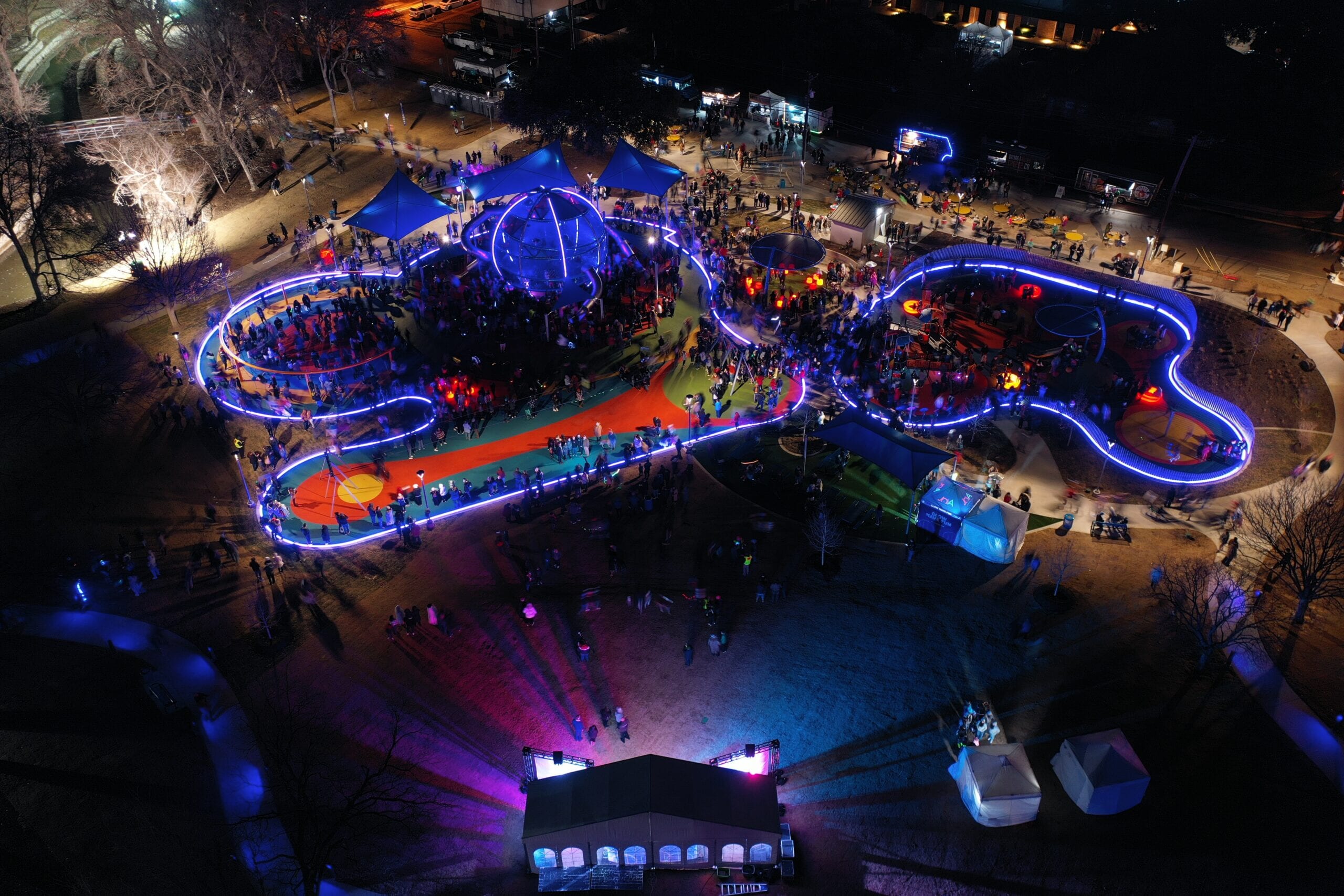 Aerial view of the Joya playground lit blue at night