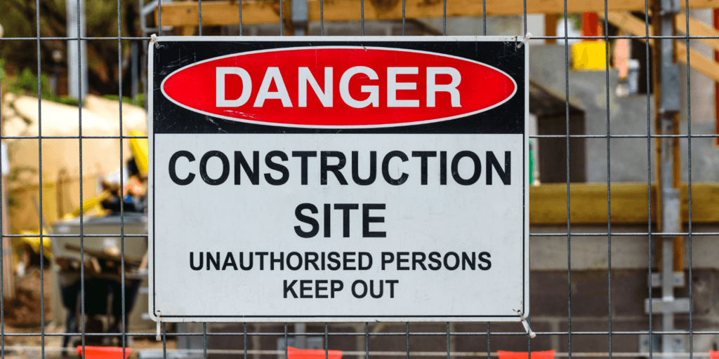 A sign that says Danger Construction Site Unauthorized Persons Keep Out on a fence to show the importance of perimeter security in construction site theft prevention