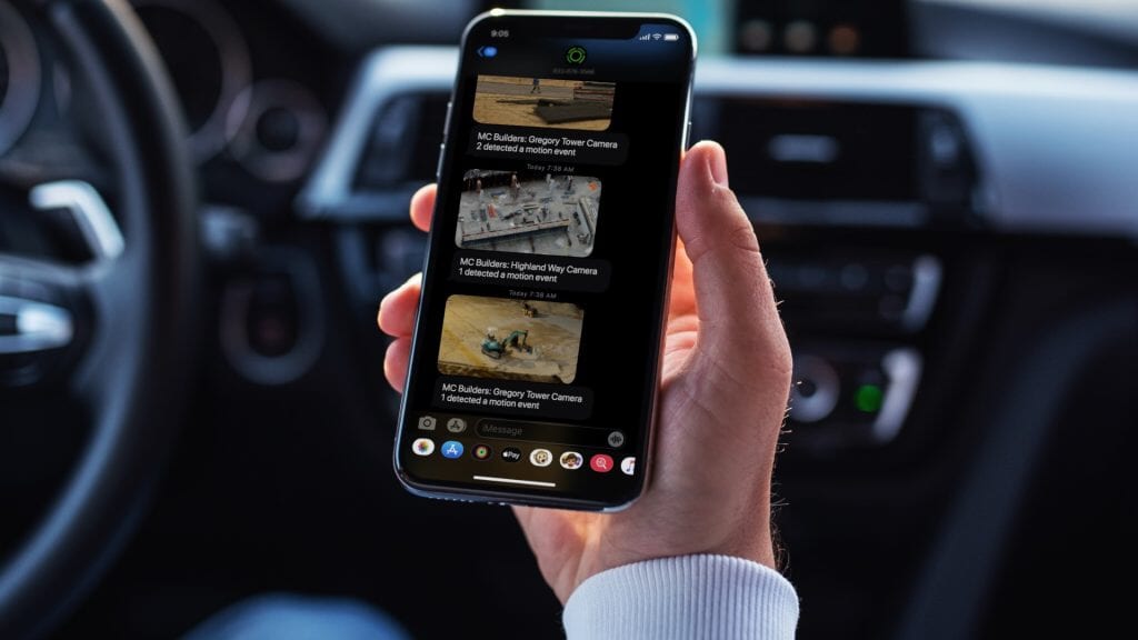holding a phone in a car showing security recordings
