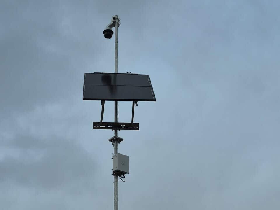 Solar-powered security camera system mounted on pole at remote construction jobsite