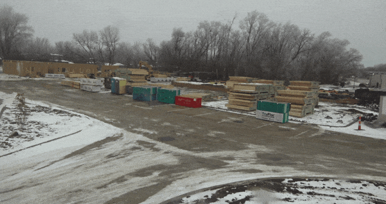 An image of a bunch of building materials and lumber sitting on out on a jobsite