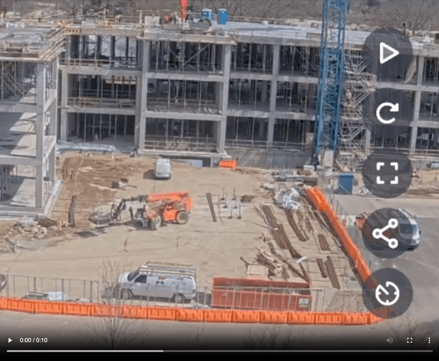 Video player showing a live camera view of a multi-story building under construction