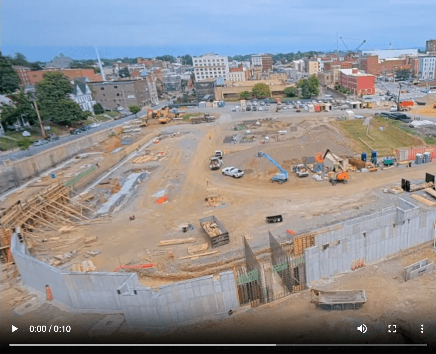 Video player showing a time-lapse of a large excavation site in a town