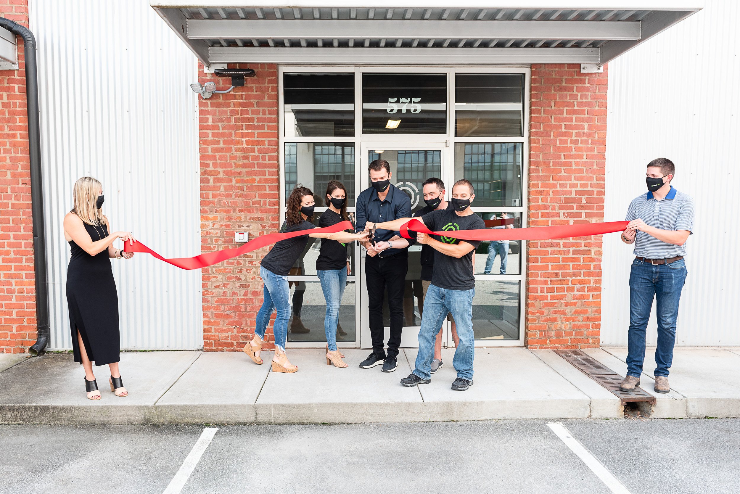 TrueLook team cutting a red ribbon outside their office