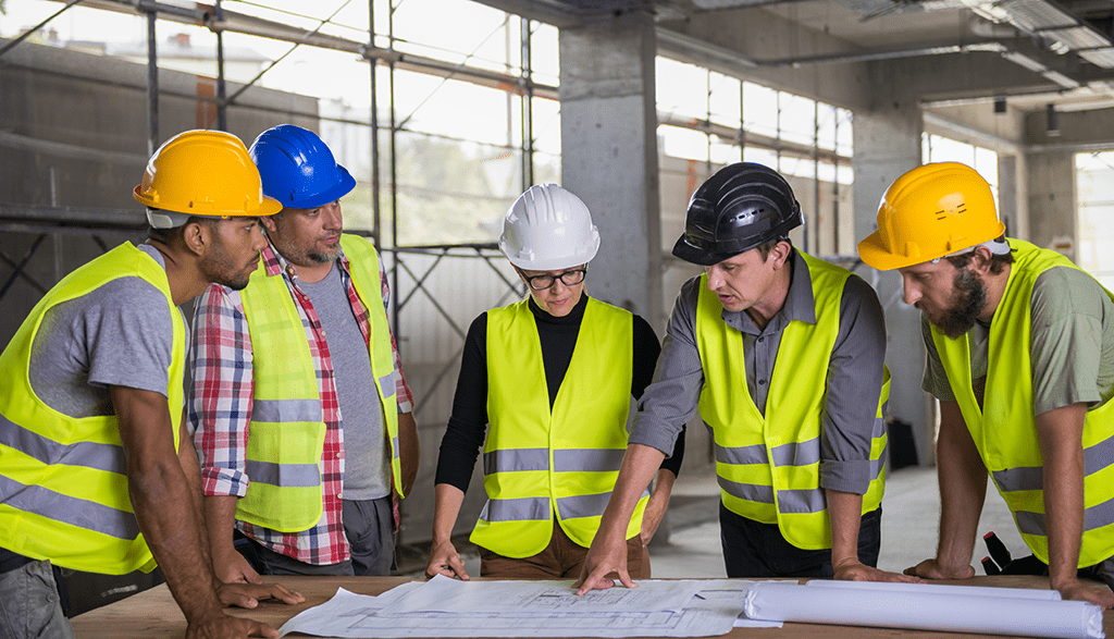 Construction team in hard hats reviewing plans