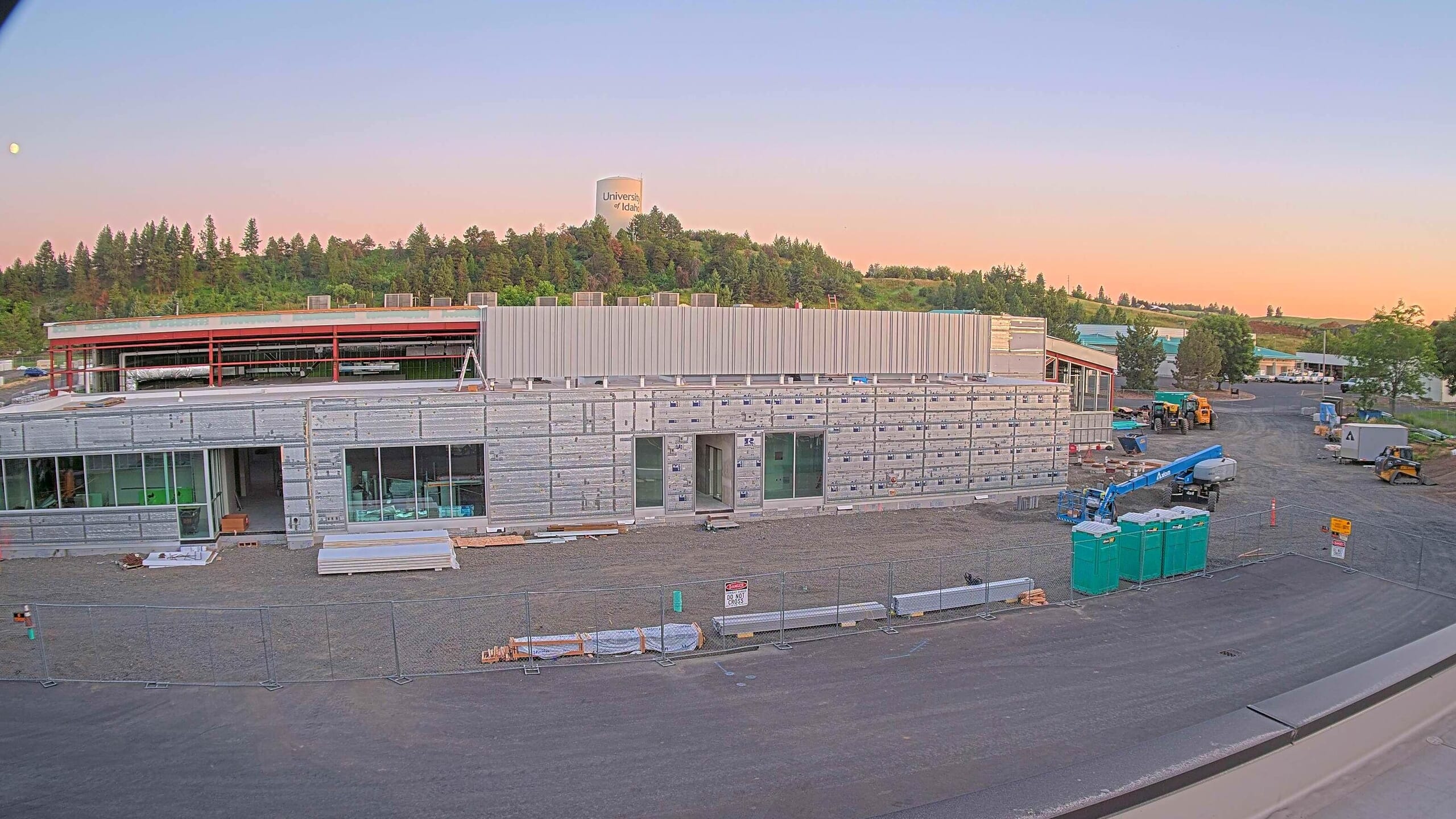 Sunset on University of Idaho campus behind the new Meat Science building in the middle of construction with porta-potties shown and materials shown around the site. 