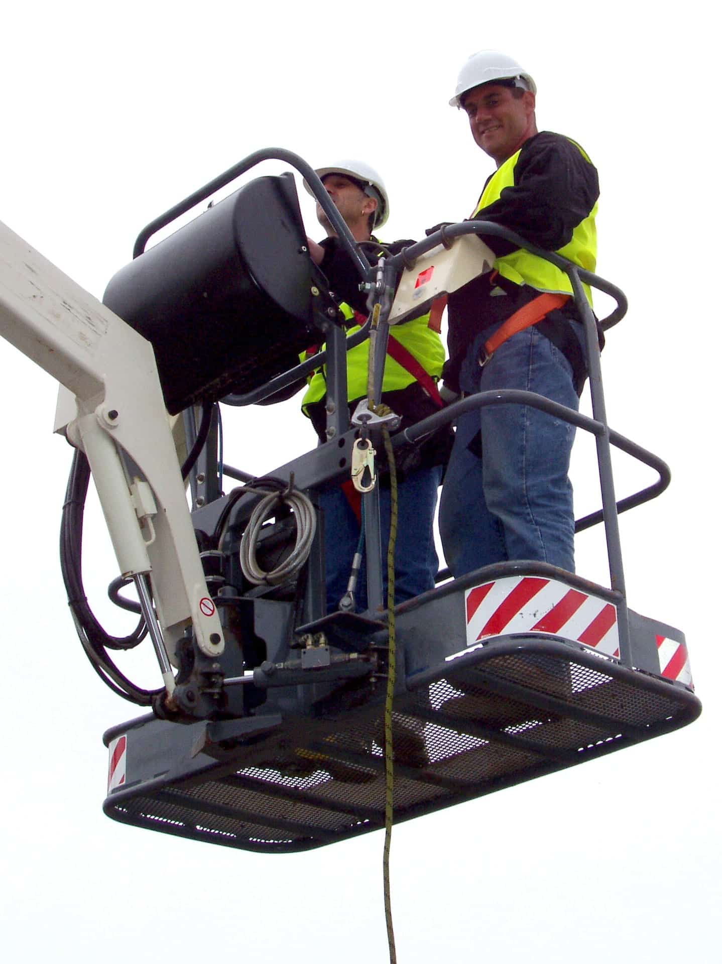 Two workers on an aerial lift installing a camera