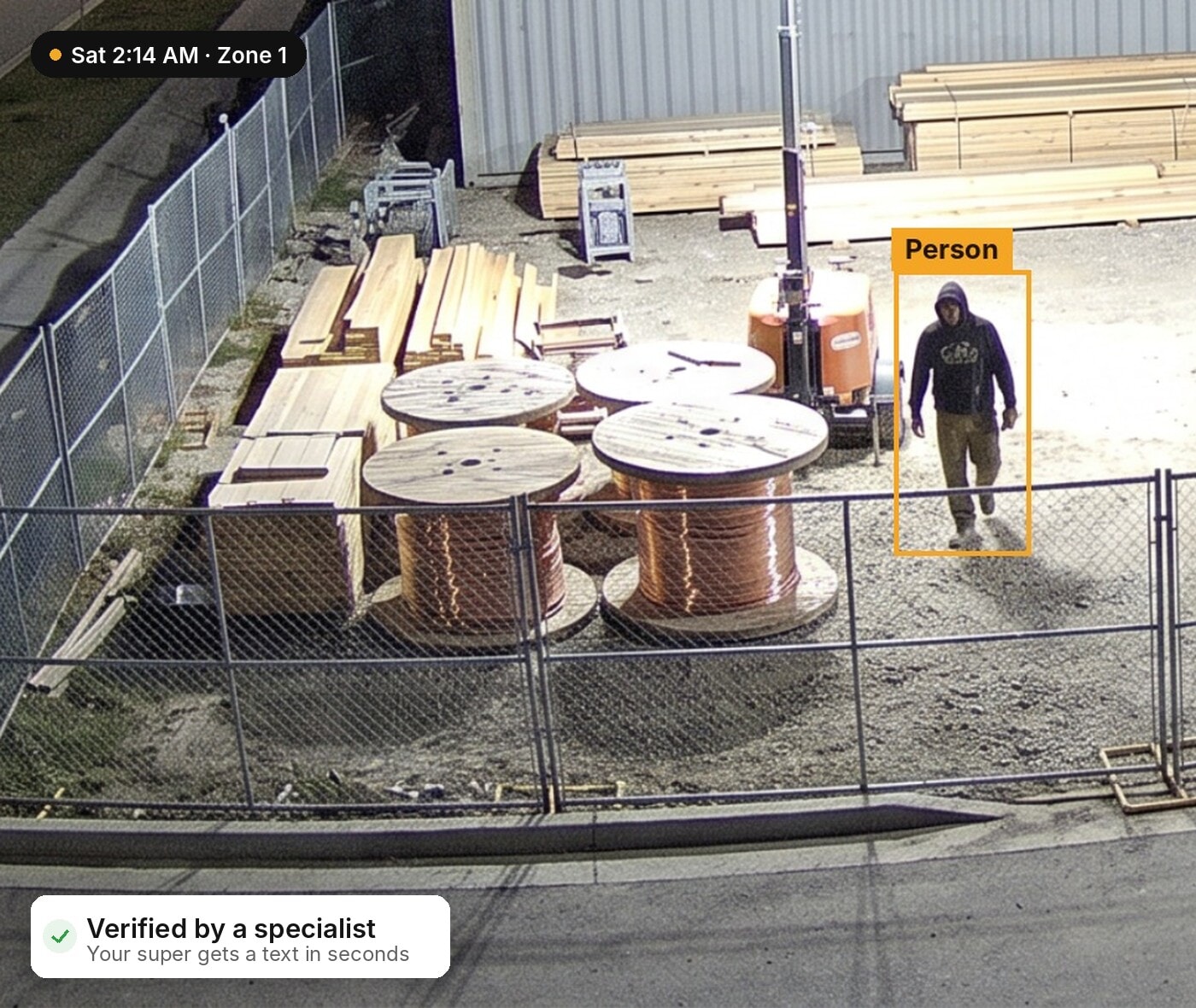 Verified person near copper wire spools on a construction site at night