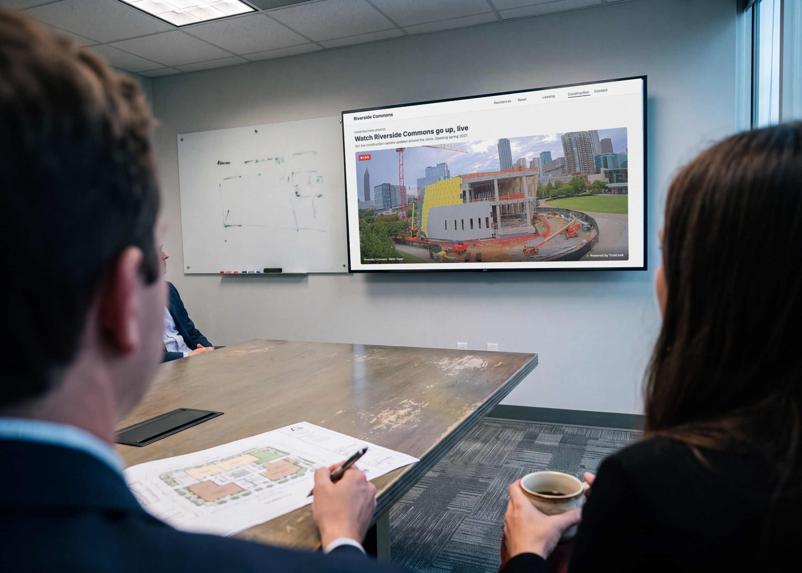 Project team in a meeting watching a live construction camera embedded on the project website