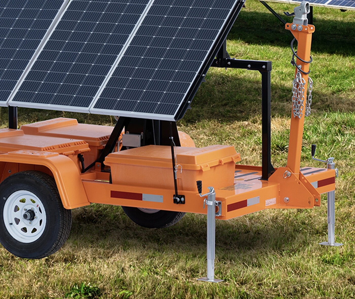 Mobile Surveillance Trailer tongue, wheel, and stabilizer jacks on a grassy site